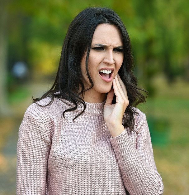 Woman in pain holding jaw