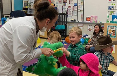 Dentist teaching kids in classroom