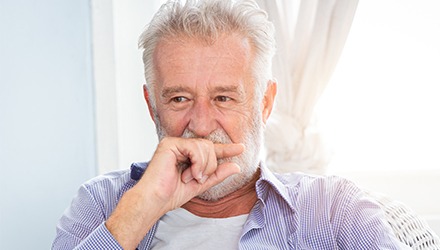 Older man covering his mouth